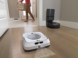 A robotic vacuum cleaning under a couch, illustrating its ability to clean hard-to-reach areas.