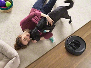  A child playing on the floor while the robotic vacuum cleans nearby, indicating safe usage around children.